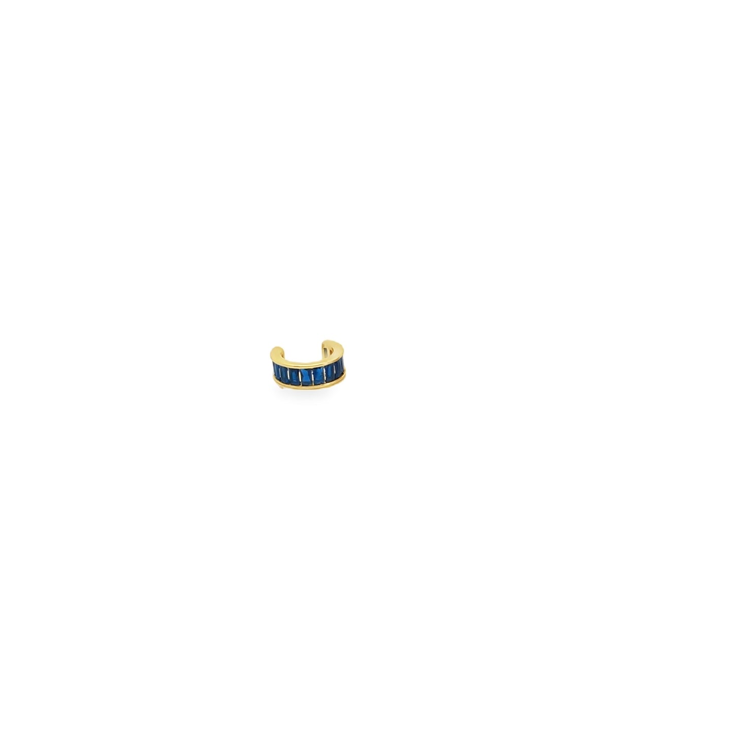 A gold ear cuff features a row of vibrant blue baguette-cut stones against a clean white background.