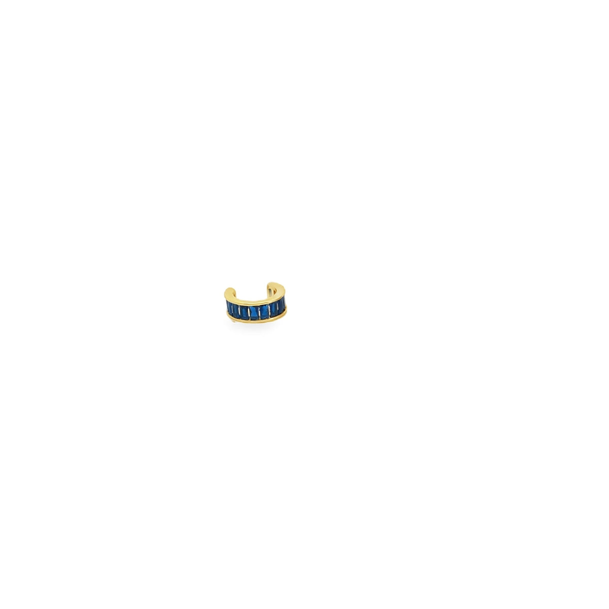A gold ear cuff features a row of vibrant blue baguette-cut stones against a clean white background.