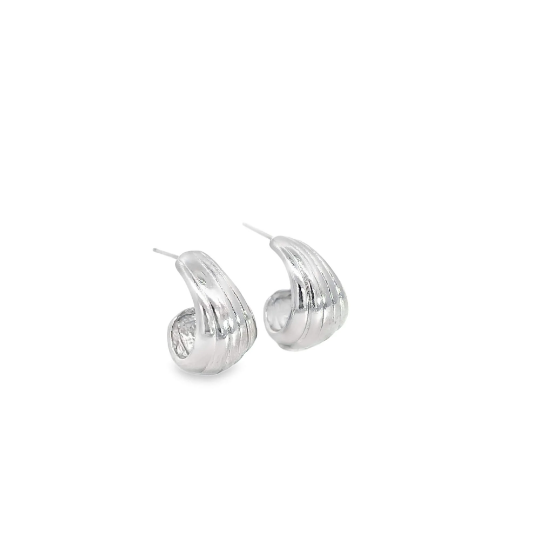 A pair of ribbed silver hoop earrings rest on a clean white surface.