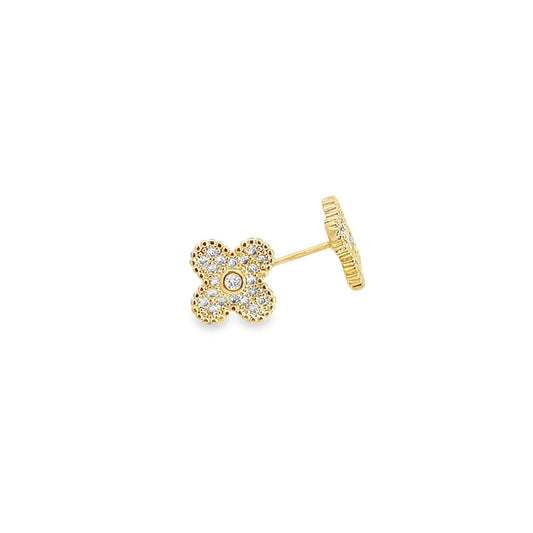 A dainty gold stud earring shaped like a four-leaf clover sparkles with inset diamonds against a clean white background.