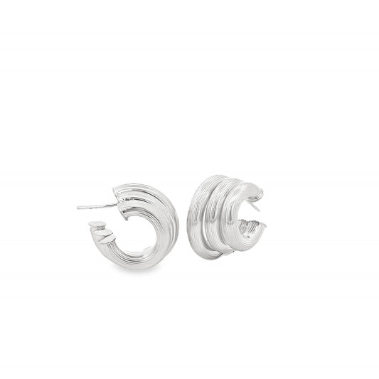 A pair of textured silver hoop earrings rests against a clean white background.