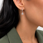 Shop pear-cut CZ drop huggie earrings featuring sparkling pavé hoops and teardrop cubic zirconia stones. 18K Gold Filled in Gold and Rhodium.