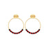 A pair of gold hoop earrings features alternating red and black beads along the bottom half, displayed against a clean white background.