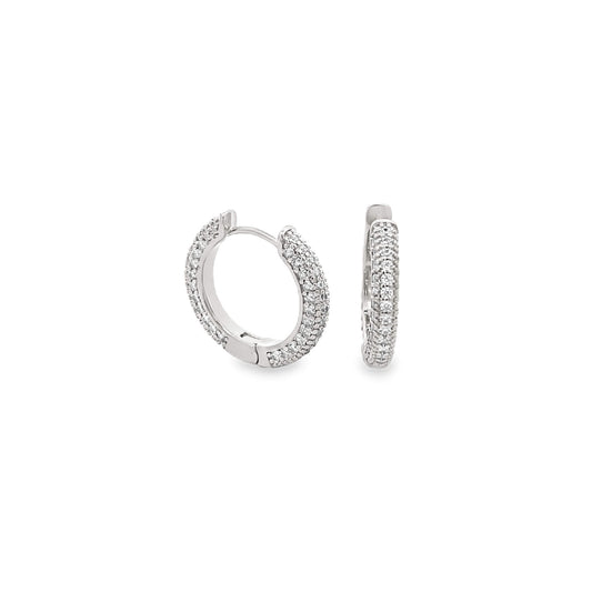 A pair of sparkling diamond pave huggie hoop earrings glitters against a clean white background.