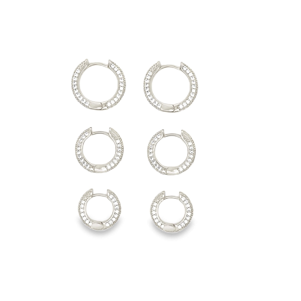Three pairs of graduated silver pavé huggie hoop earrings display sparkling cubic zirconia stones against a clean white background.