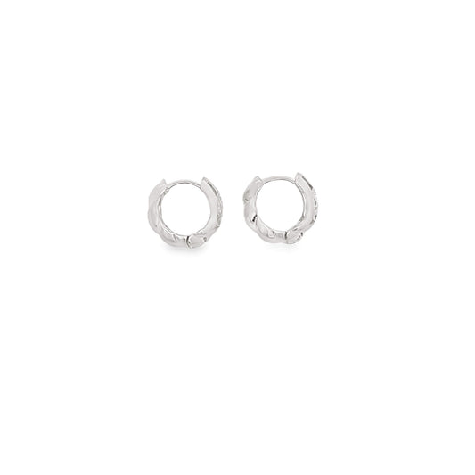 A pair of small, textured silver hoop earrings rests against a clean white background.