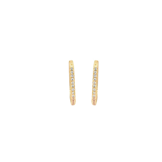 A pair of delicate gold huggie hoop earrings embedded with small sparkling diamonds sparkles against a plain white background.