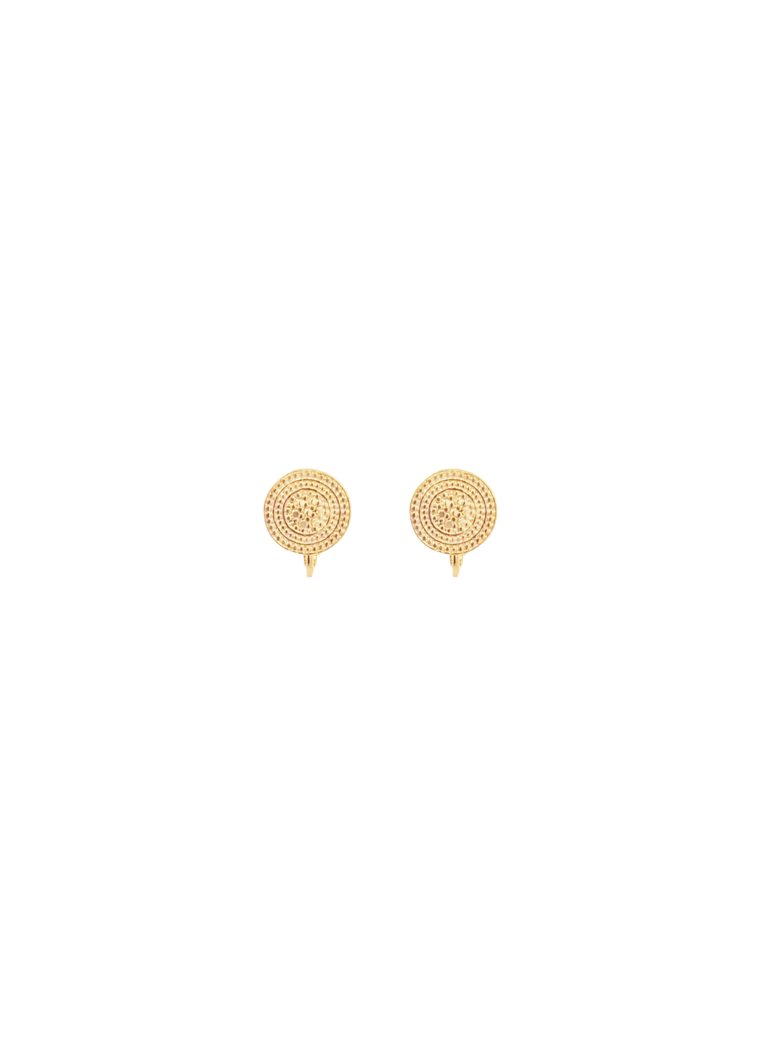 A pair of gold clip-on earrings featuring intricate circular patterns rests against a clean white background.