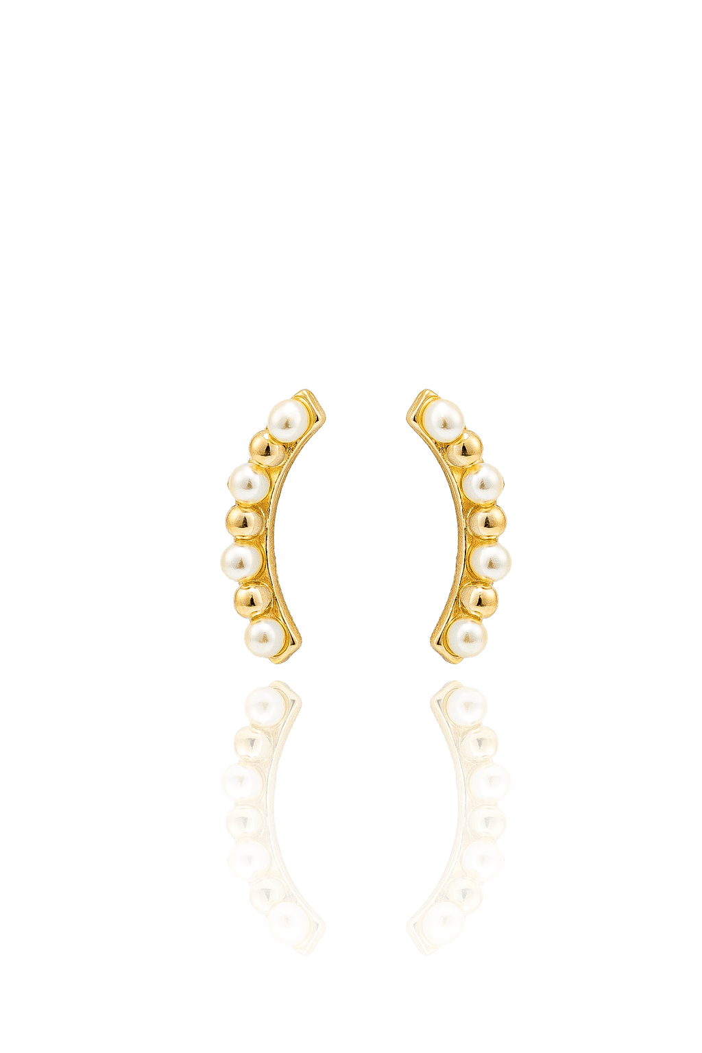 A pair of curved gold earrings adorned with alternating white pearls and gold beads displays a glossy reflection on a white surface.
