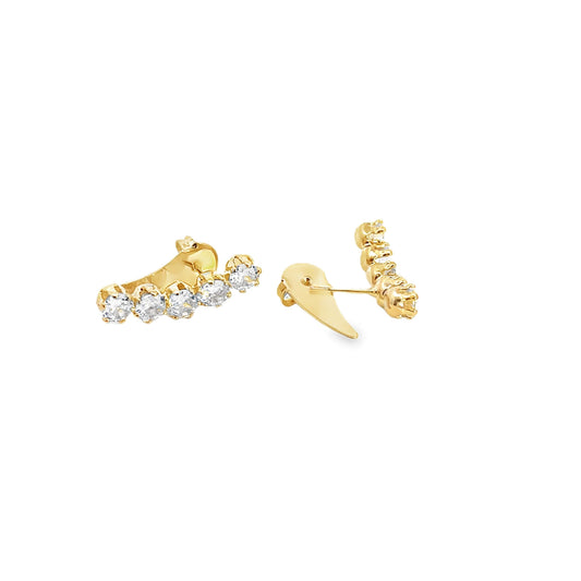 A pair of gold diamond ear crawler earrings gleam against a clean white background.