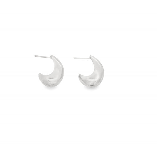 A pair of polished silver crescent-shaped huggie earrings rests against a clean white background.