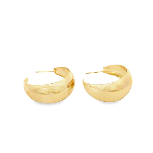 A pair of thick, polished gold hoop earrings rests against a clean white background.