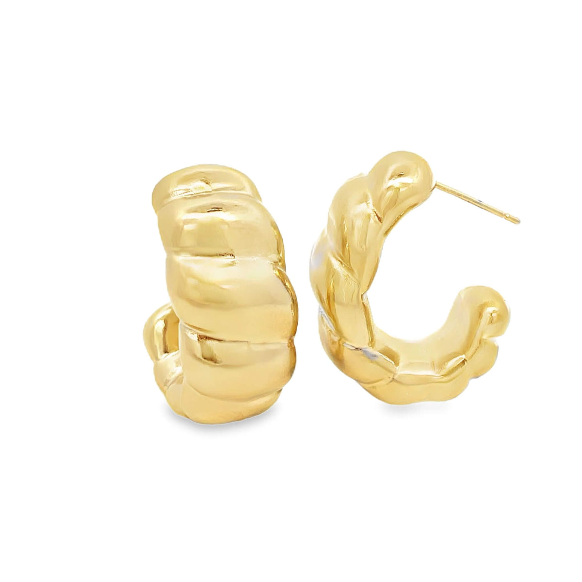 A pair of chunky gold hoop earrings with a textured, quilted design rest on a white background.