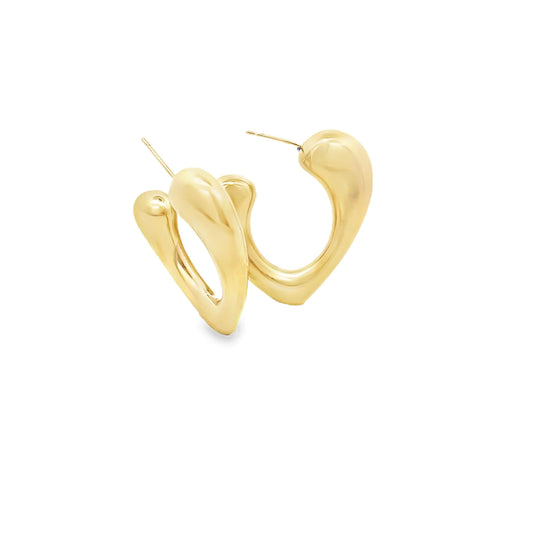 A pair of chunky gold hoop earrings with an organic teardrop design rests against a clean white background.