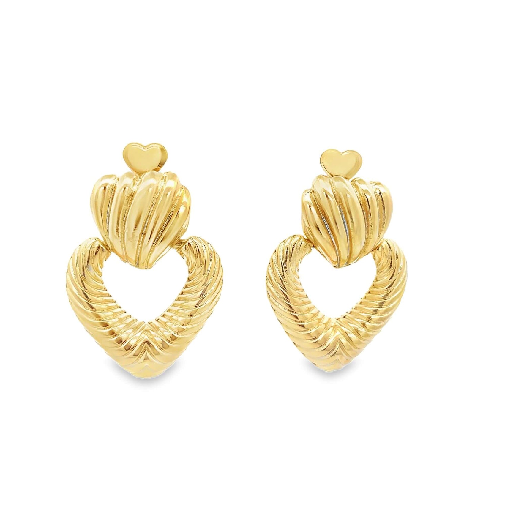 A pair of ornate gold earrings features textured heart-shaped loops topped with fluted shell motifs and small heart studs against a plain white background.