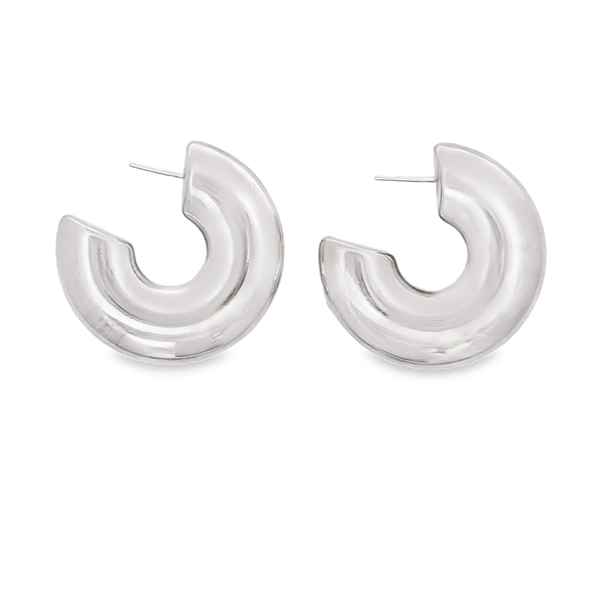 A pair of thick, polished silver hoop earrings rests against a clean white background.