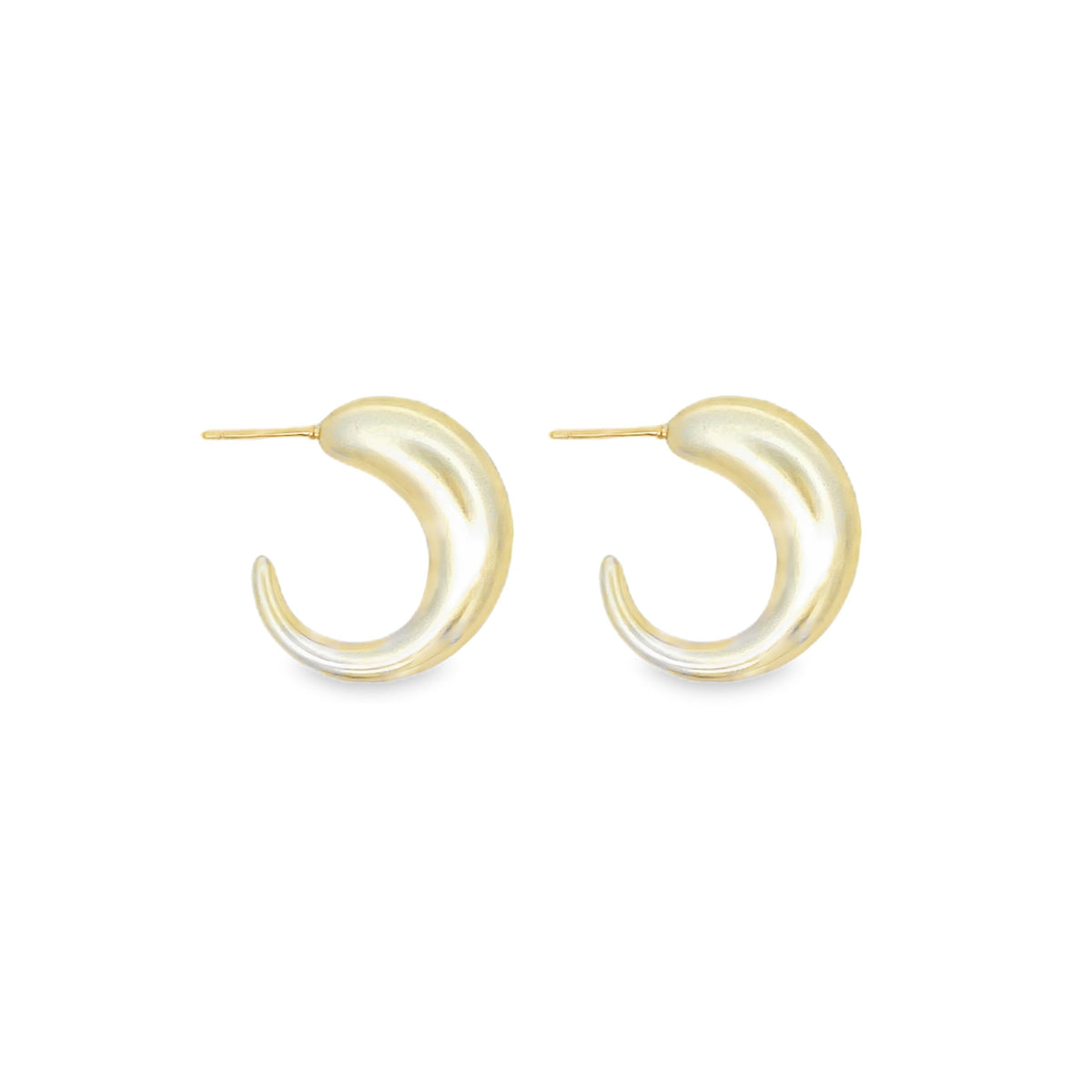 A pair of thick, crescent-shaped gold hoop earrings rests against a clean white background.