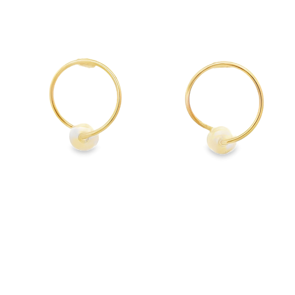 A pair of gold hoop earrings features a single pearl bead threaded onto the bottom of each circle against a clean white background.