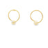 A pair of gold hoop earrings features a single pearl bead threaded onto the bottom of each circle against a clean white background.