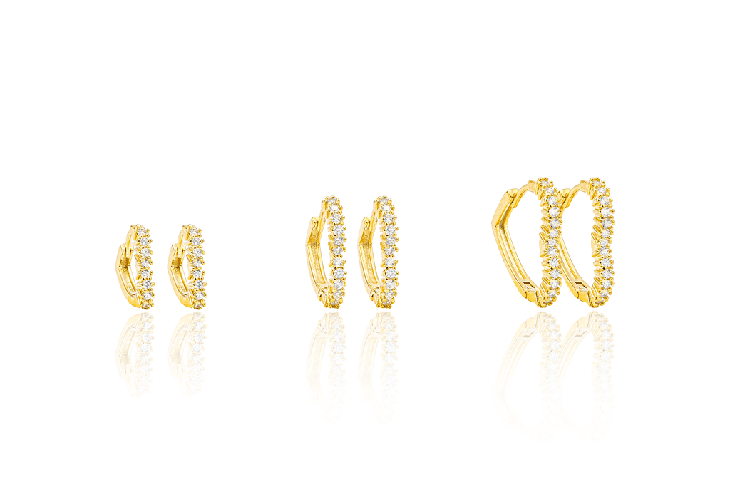 Three pairs of gold huggie hoop earrings featuring sparkling pave-set diamonds are displayed in ascending sizes against a white background.