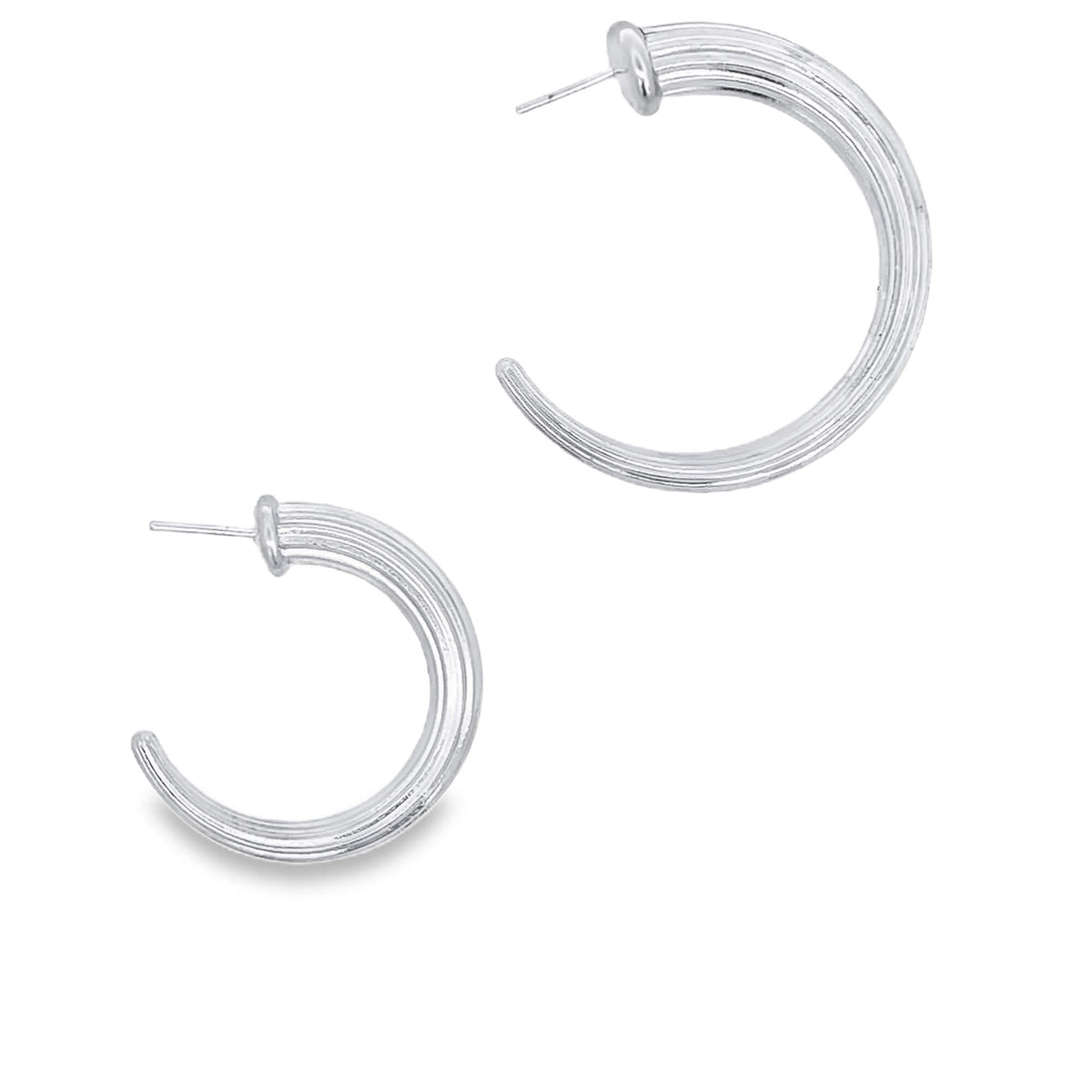 A pair of ribbed silver hoop earrings gleams against a clean white background.