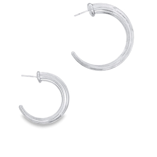 A pair of ribbed silver hoop earrings gleams against a clean white background.