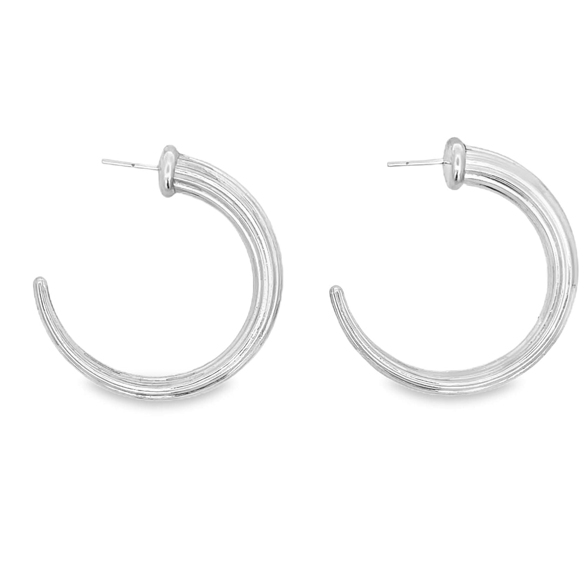 A pair of silver hoop earrings features a thick, ribbed design against a plain white background.