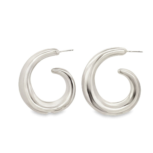 A pair of polished silver chunky hoop earrings features a distinct swirl design on a plain white background.
