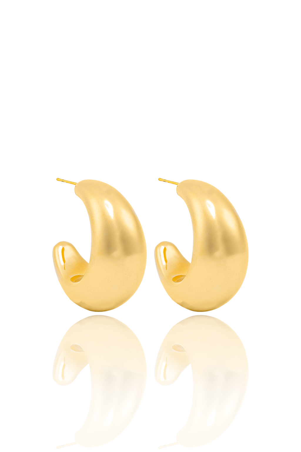A pair of glossy gold chunky hoop earrings rests on a reflective white surface.