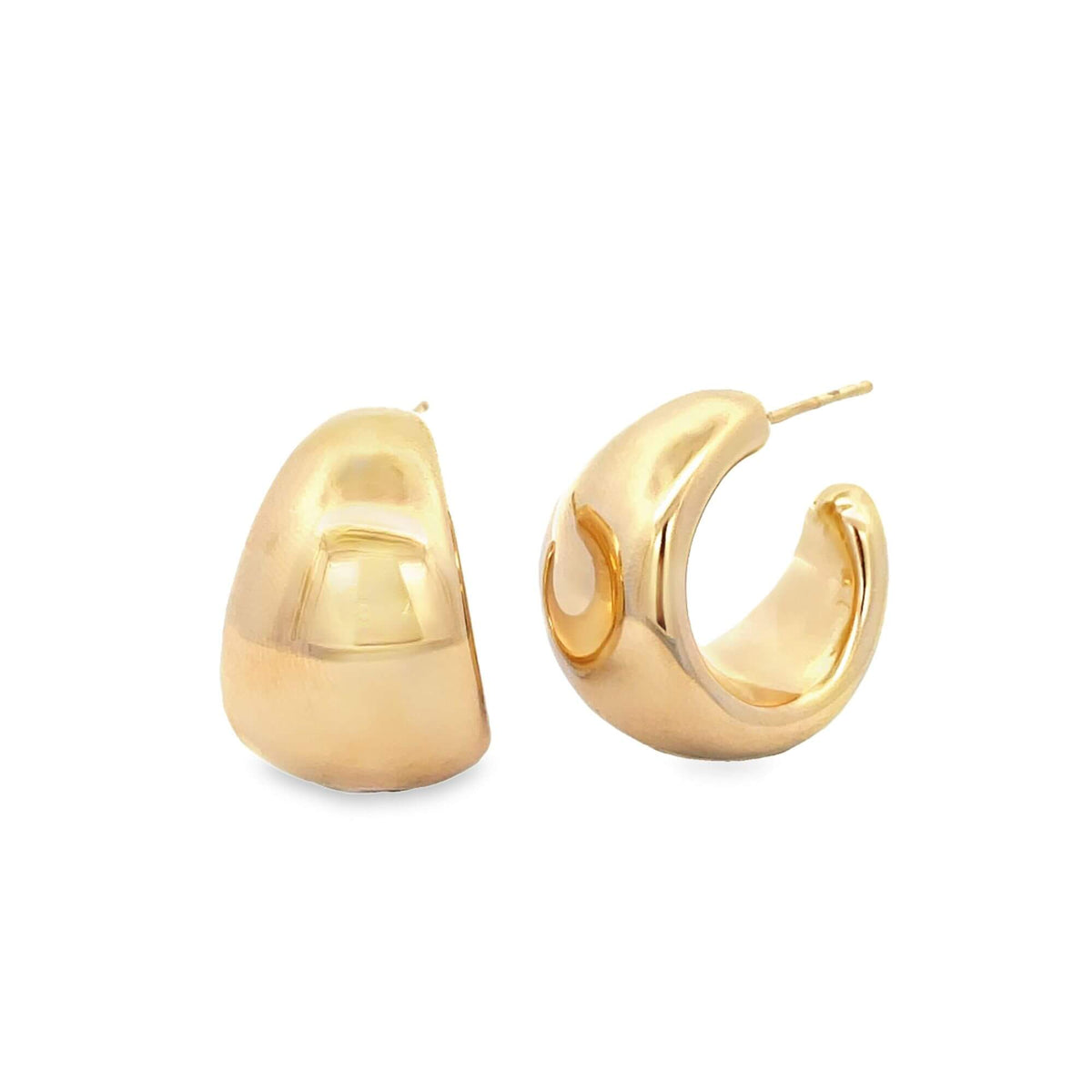 A pair of thick, glossy gold huggie hoop earrings rests against a clean white background.