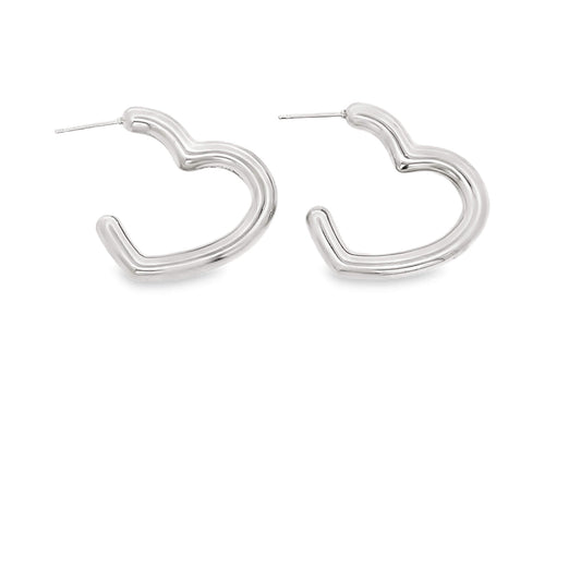 A pair of polished silver heart-shaped hoop earrings rests against a clean white background.