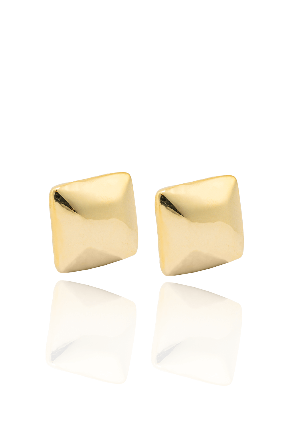 A pair of polished gold square stud earrings sits on a reflective white surface.
