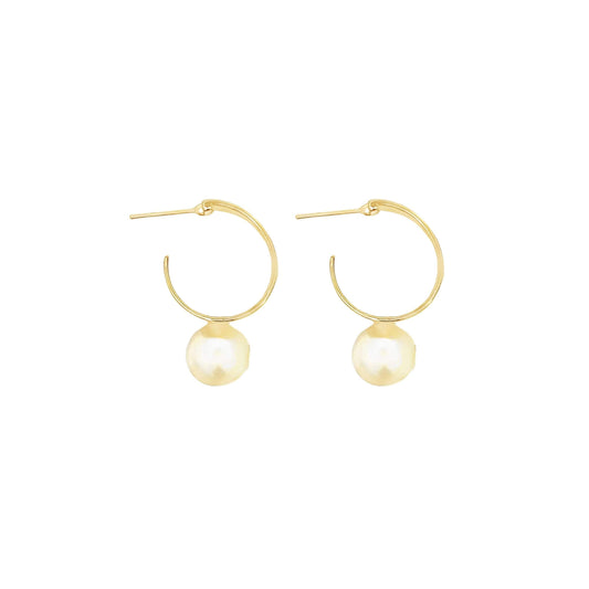 A pair of gold hoop earrings features hanging pearl charms against a plain white background.