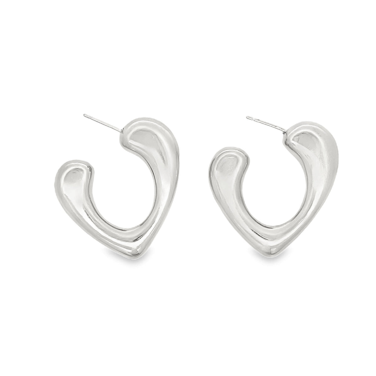 A pair of chunky silver hoop earrings features a sleek, abstract heart shape against a white background.