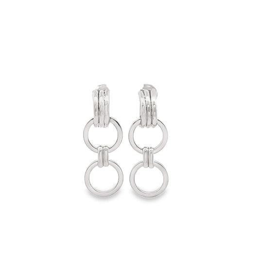 A pair of polished silver drop earrings features intersecting circular hoops against a clean white background.