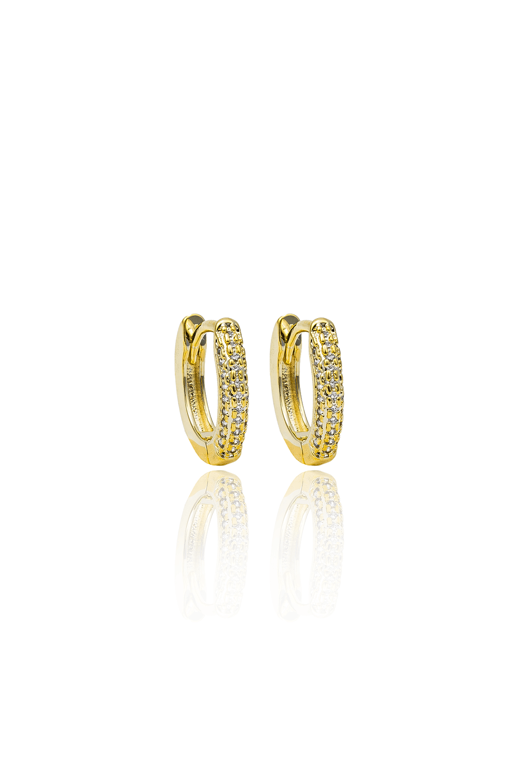 A pair of sparkling gold huggie earrings featuring embedded pavé diamonds rests upright against a clean white background, reflecting softly below.