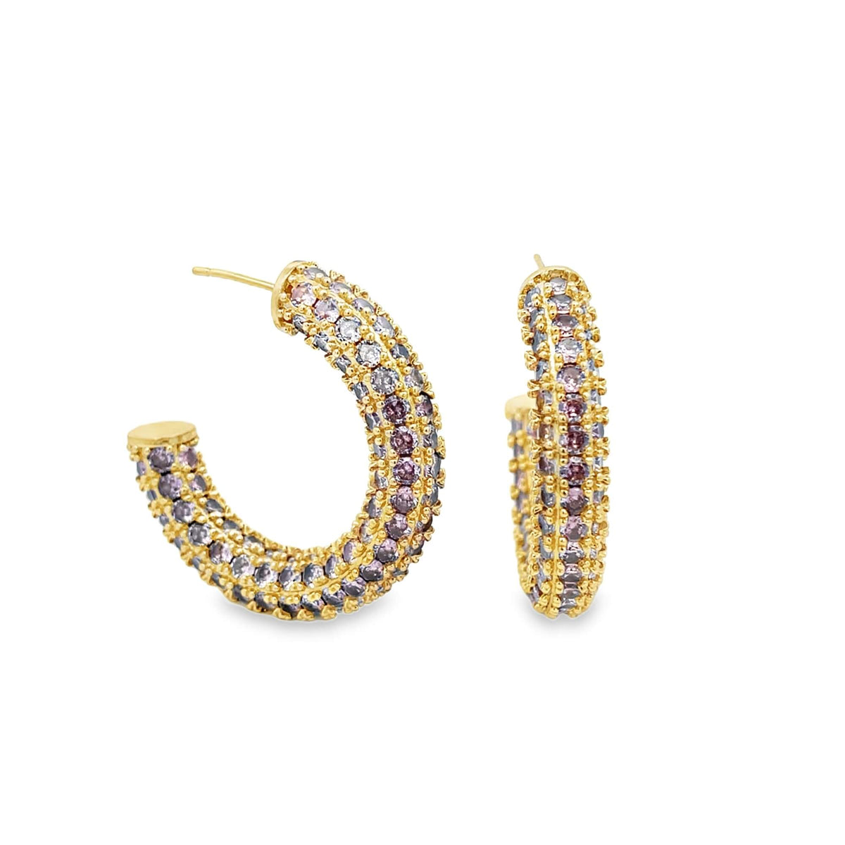 A pair of gold hoop earrings sparkle with encrusted multi-colored pink and purple gemstones against a clean white background.