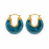 A pair of gold-accented blue resin hoop earrings rests against a clean white background.
