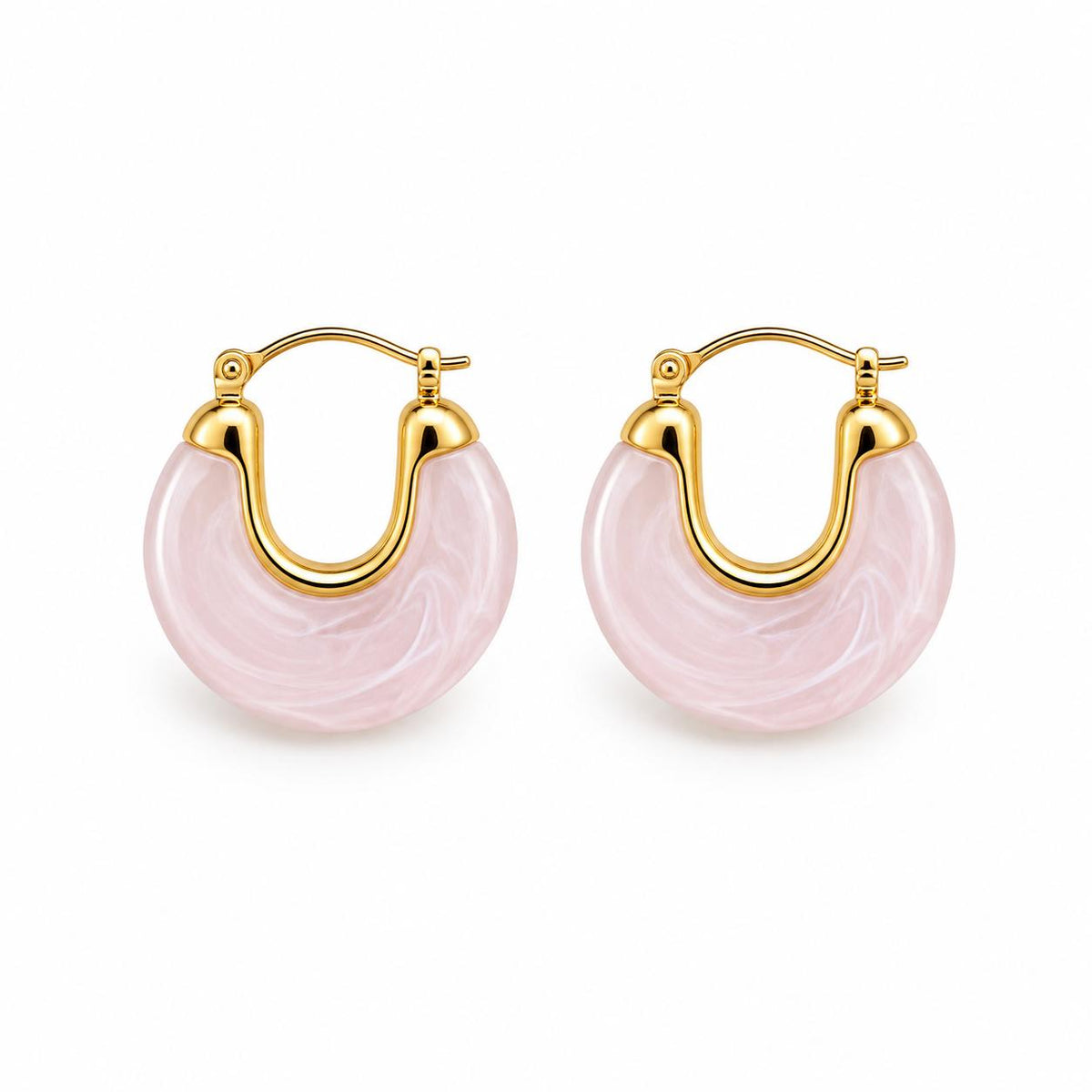 A pair of gold hoop earrings featuring polished pink marble stone accents rests against a clean white background.