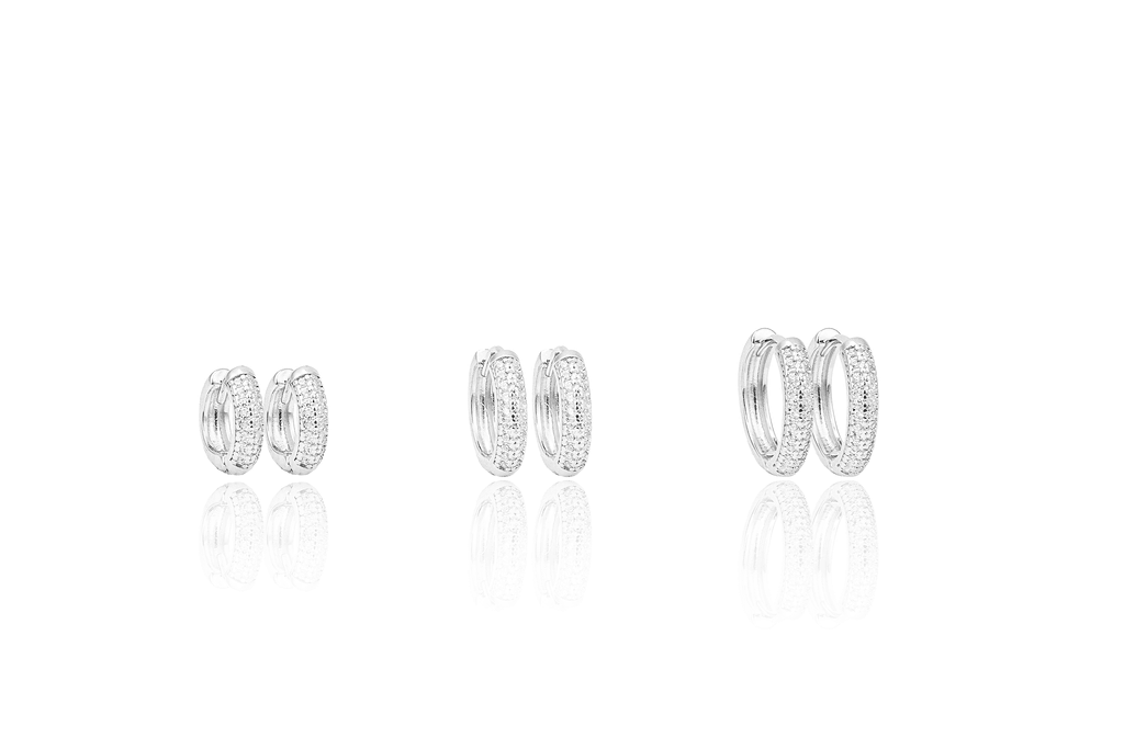Three pairs of sparkling silver pave hoop earrings are displayed in graduating sizes against a clean white background.
