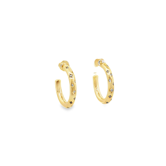 A pair of gold starburst hoop earrings rests against a white background.