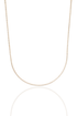 A sparkling diamond tennis necklace drapes gracefully against a white background with a soft reflection below.