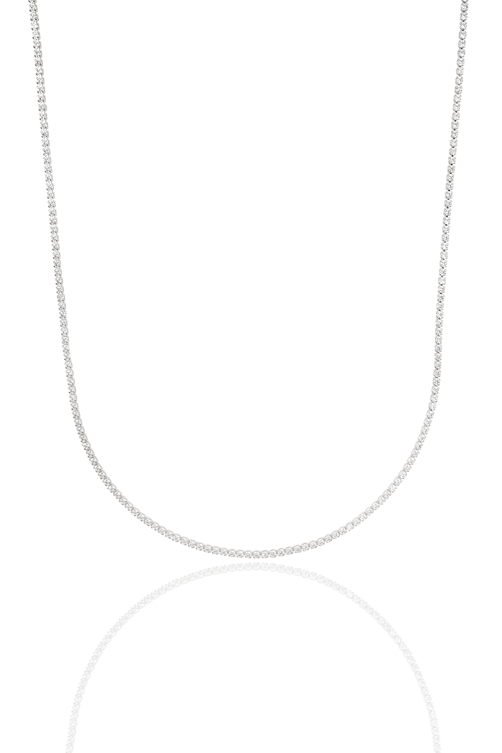 A sparkling diamond tennis necklace drapes gracefully against a white background, casting a soft reflection below.