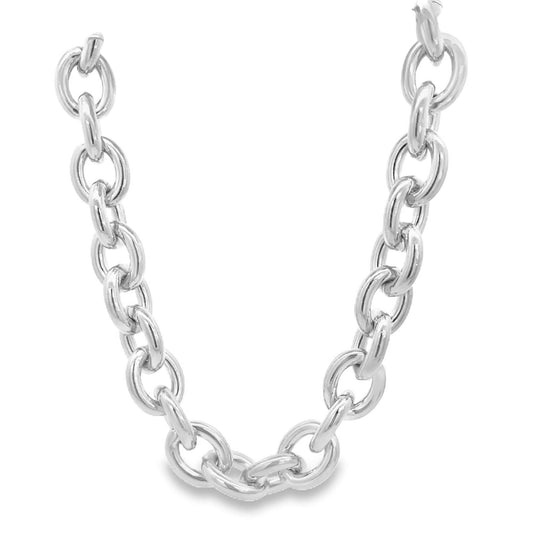 A thick, polished silver chain necklace curves gracefully against a plain white background.