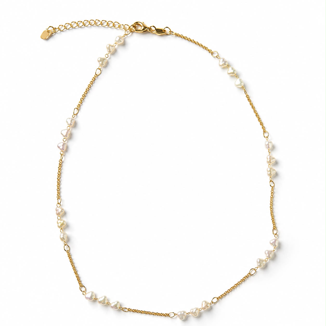 A delicate gold chain necklace features scattered white heart-shaped pearls on a plain white background.
