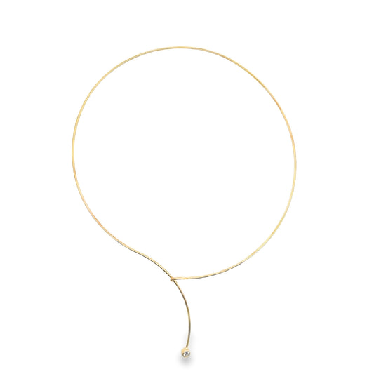 A delicate gold choker necklace features a thin wire loop with a single sparkling diamond pendant dangling at the bottom.