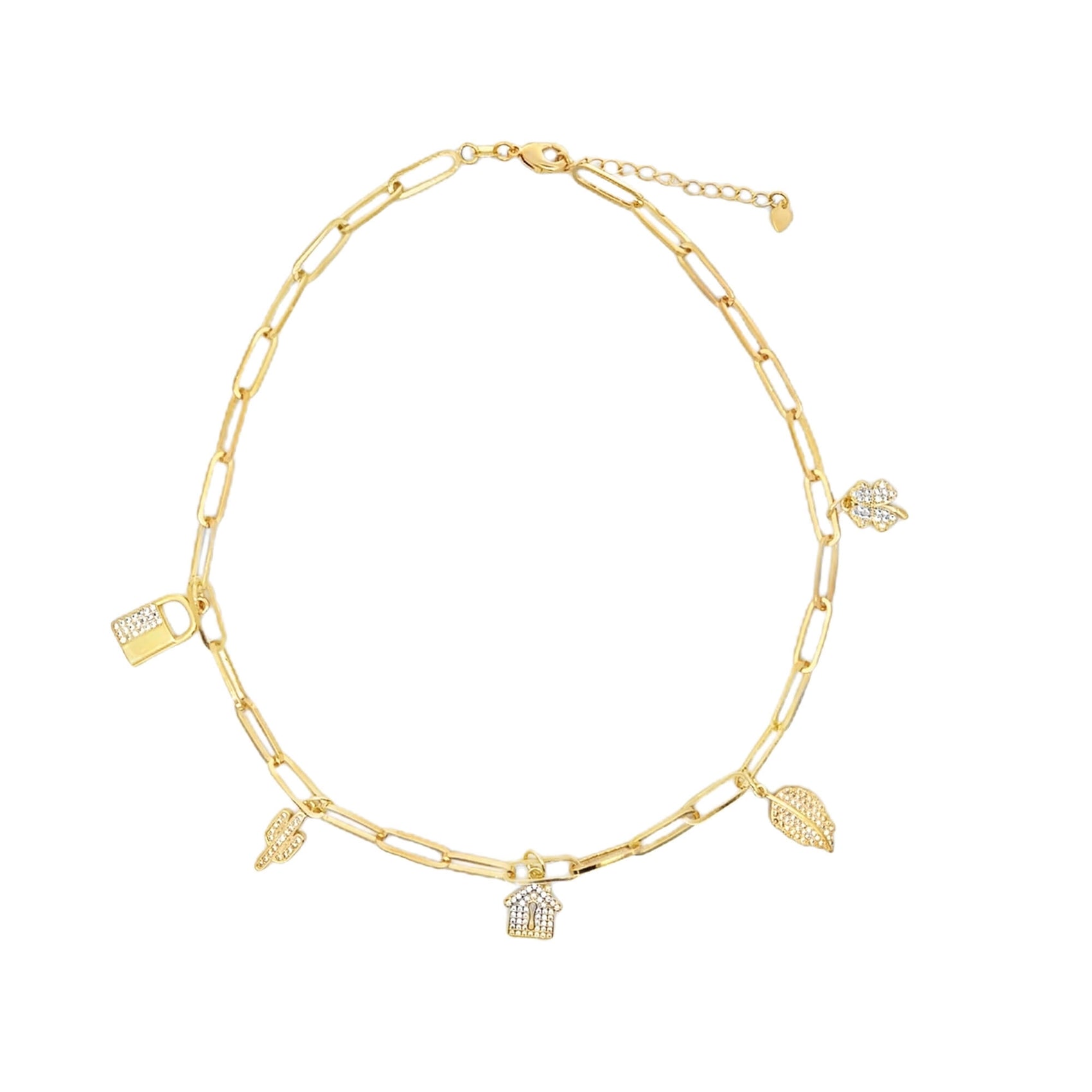 A gold paperclip chain necklace features dangling charms shaped like a house, lock, leaves, and a flower, all embellished with sparkling crystals against a clean white background.