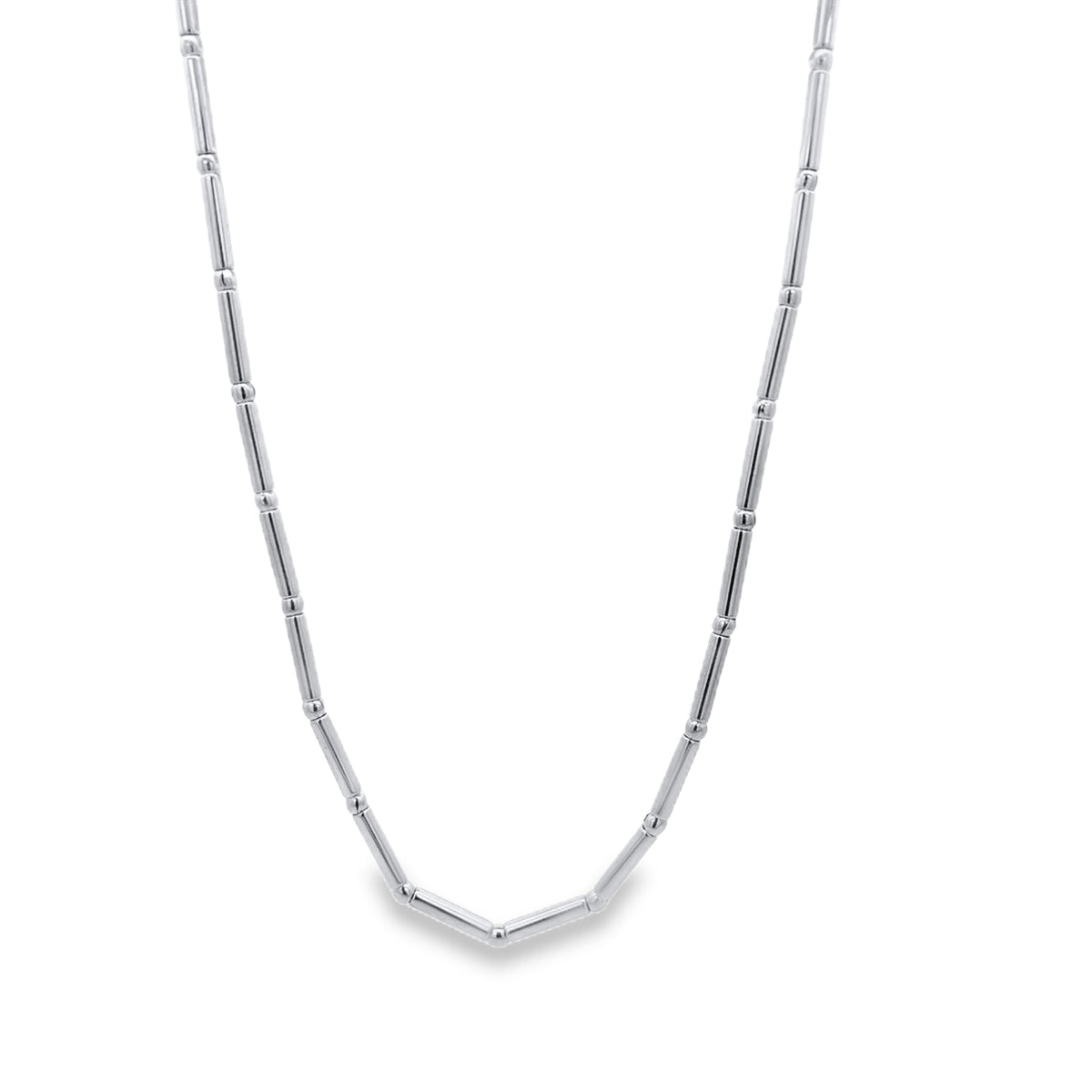 A sleek silver bar and bead station necklace hangs in a graceful curve against a clean white background.