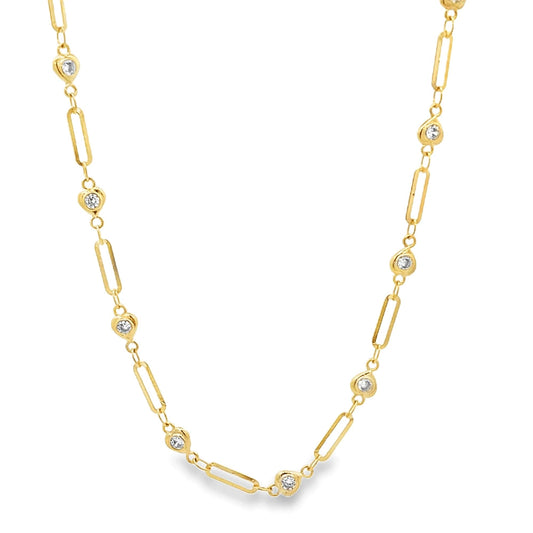 A delicate gold paperclip chain necklace features alternating diamond bezel stations against a plain white background.