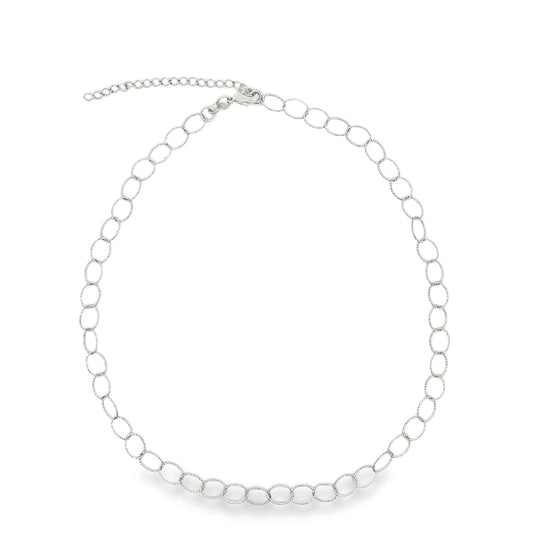 A delicate silver link choker necklace curves gracefully against a plain white background, showcasing its sparkling interlocking circles and adjustable extender chain.